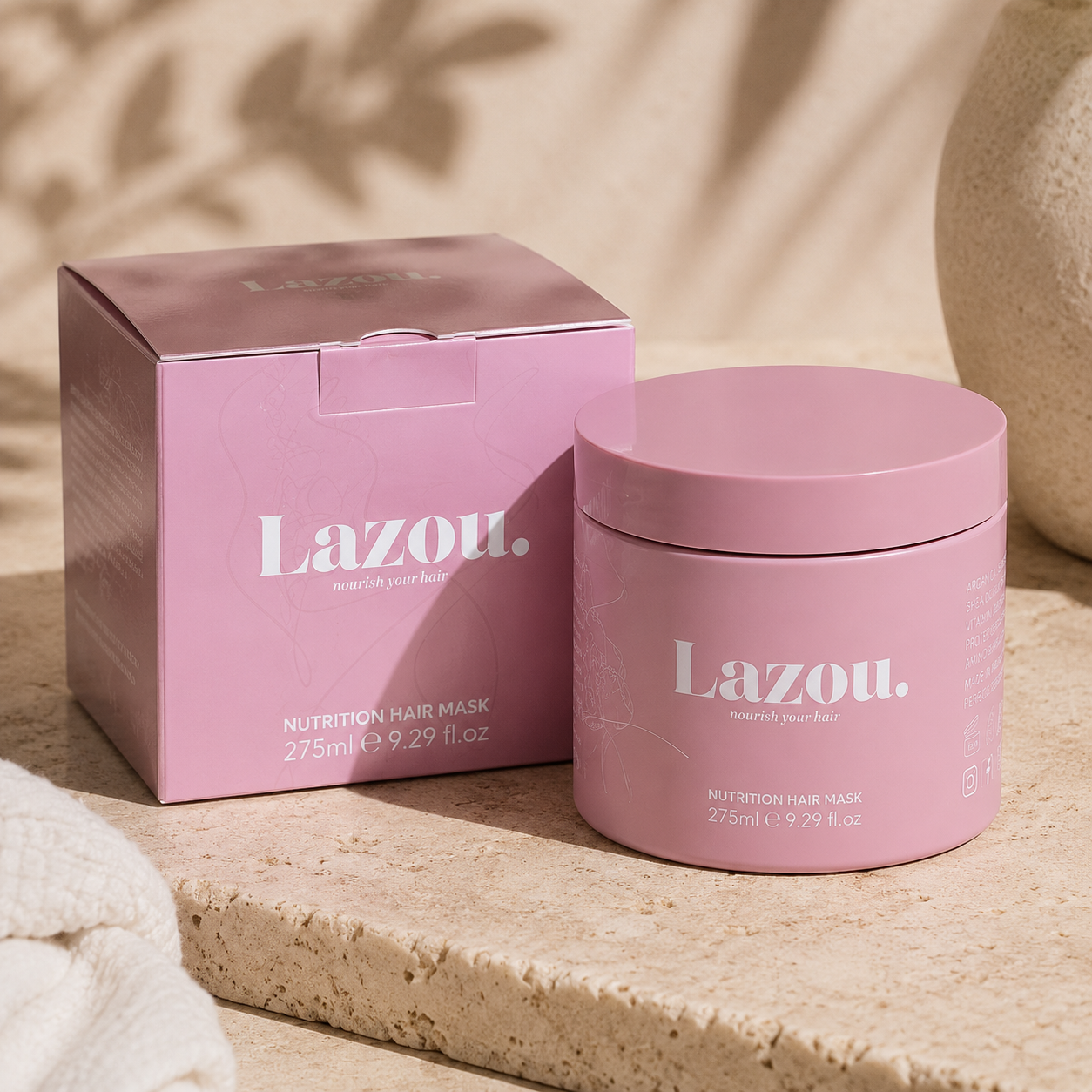 Pink Lazou hair mask jar and box on a beige surface