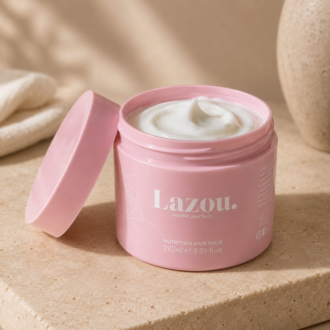 Pink jar of Lazou hair mask on a beige surface