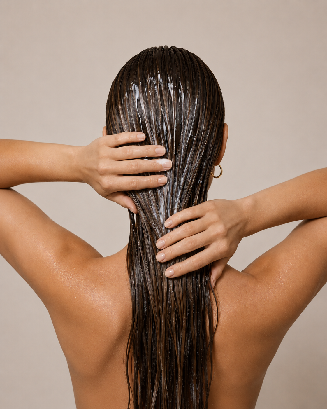 Person with wet hair against a beige background